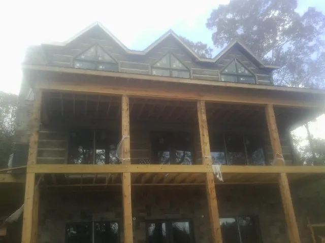 Dormers and porch framing on a large log home under construction — Roof Coating work by our crew in Tunkhannock