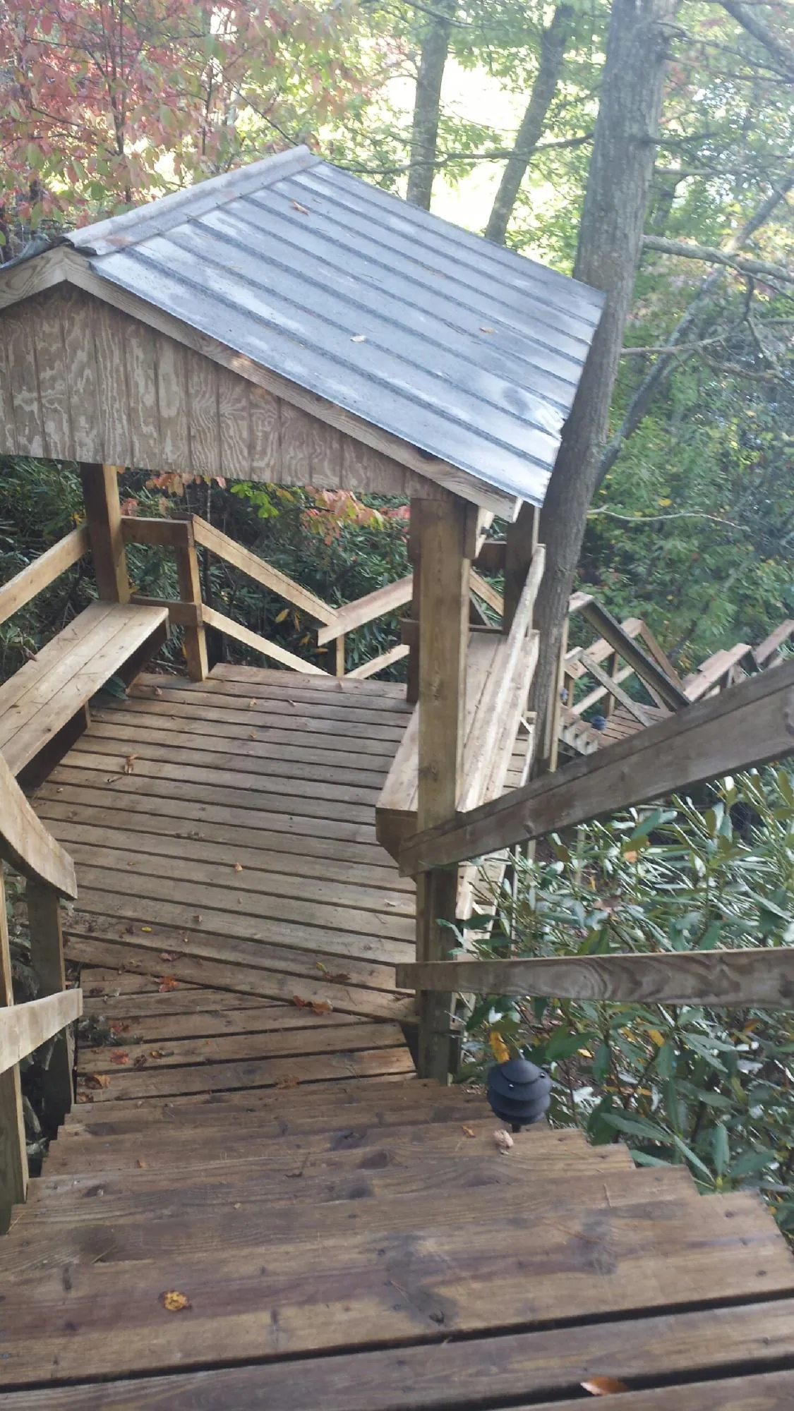 Metal roofed shelter over wooden steps on a wooded walkway — Skylight Repair & Installation work by our crew in Tunkhannock