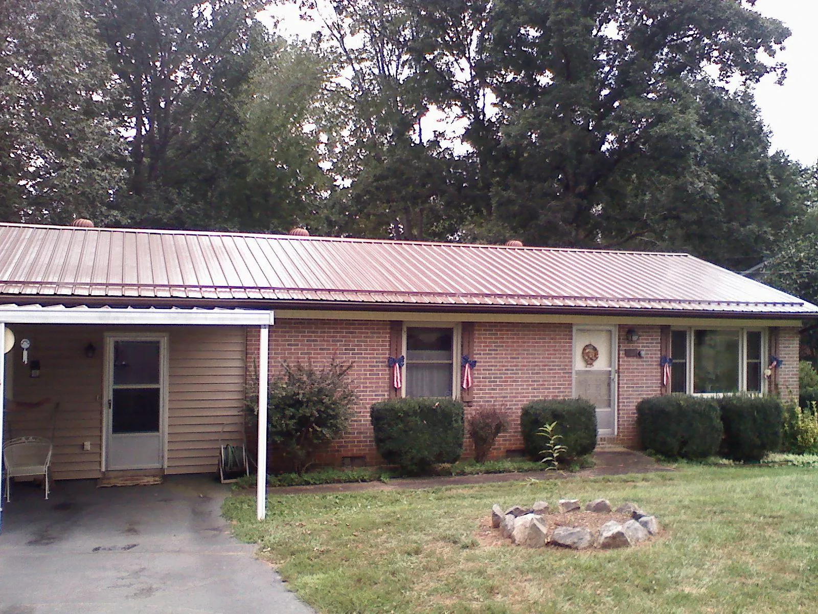 Bronze metal roof and carport on a brick ranch home — Roof Repair work by our crew in Tunkhannock